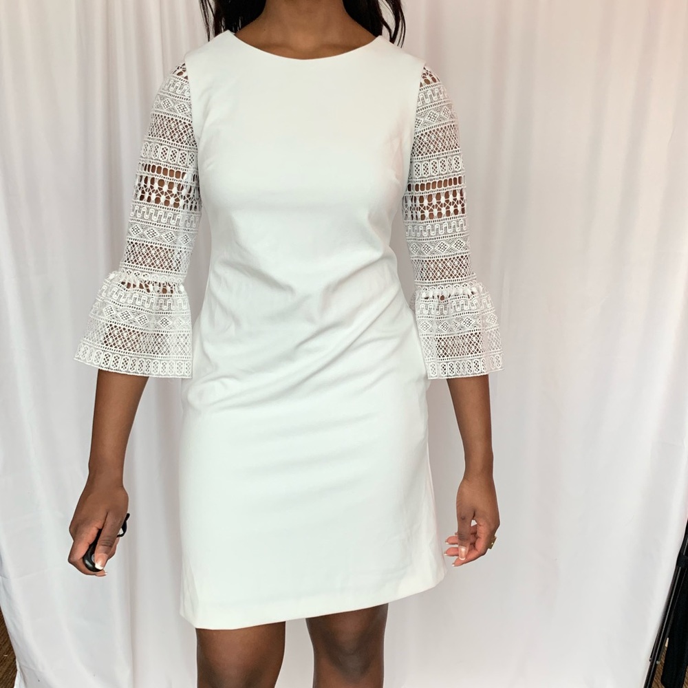 White cocktail knee length dress with lace sleeves. It is gently used.